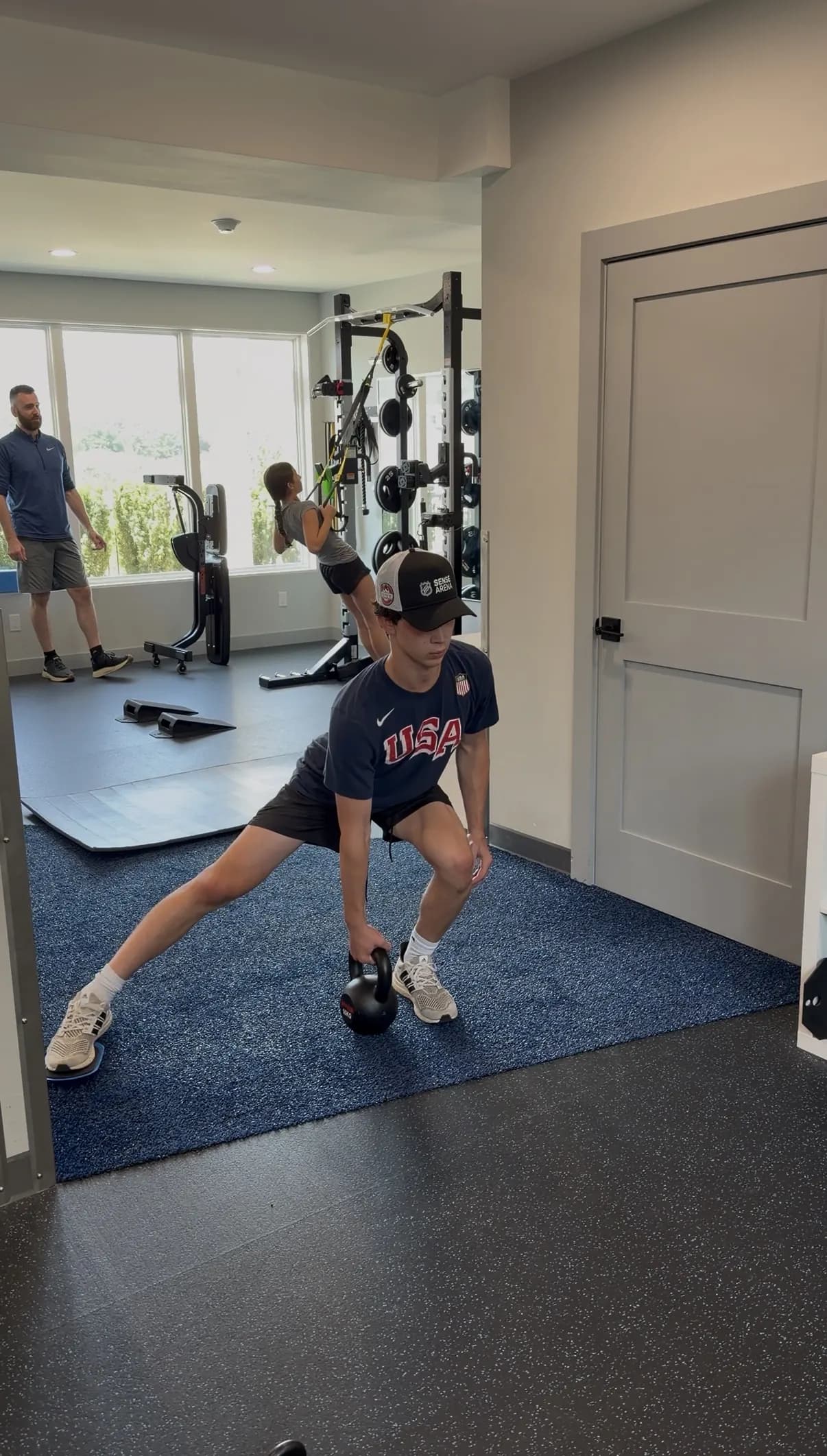 Client doing kettlebell lunges in the studio