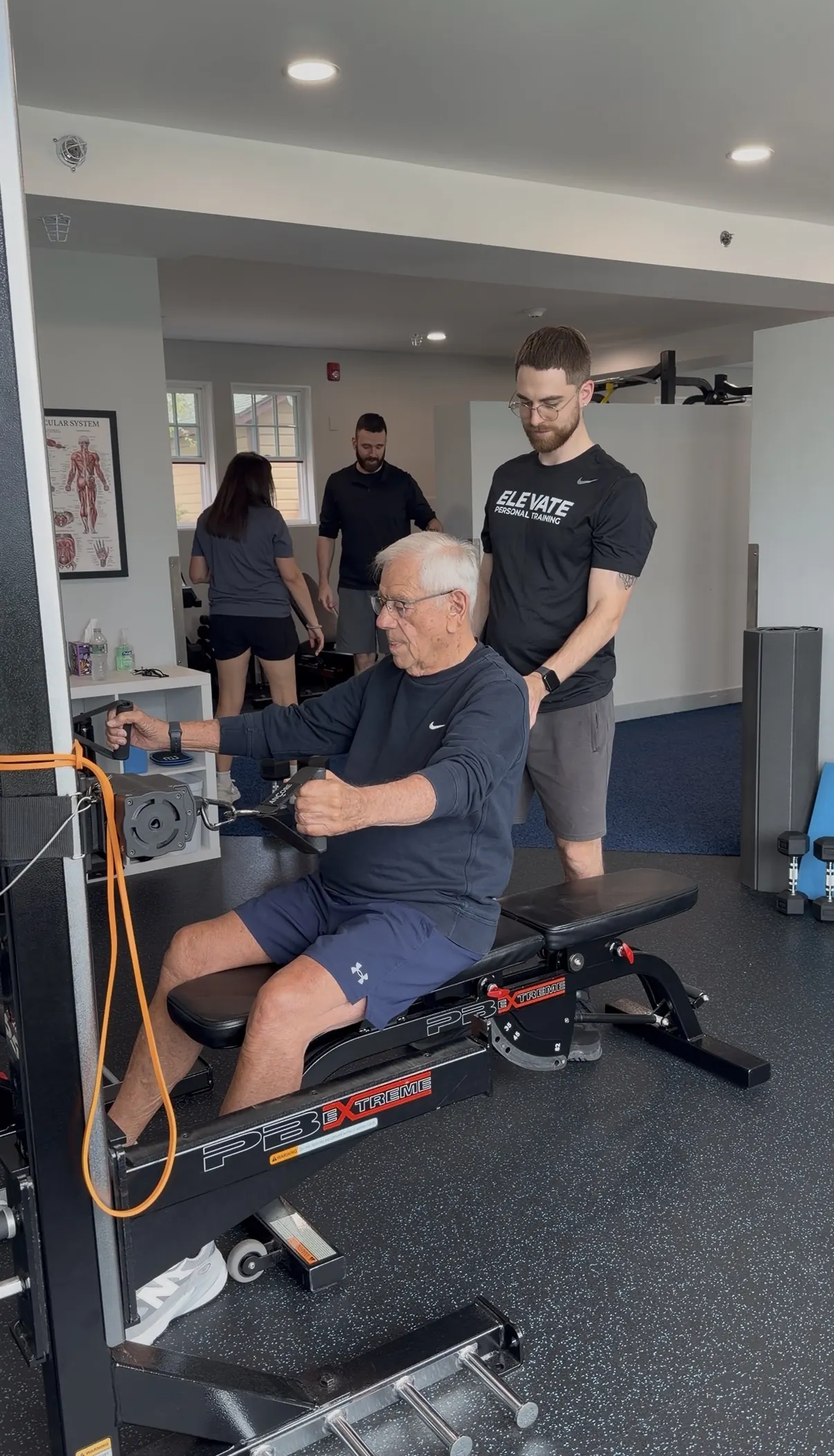 Trainer guiding a client on the seated row